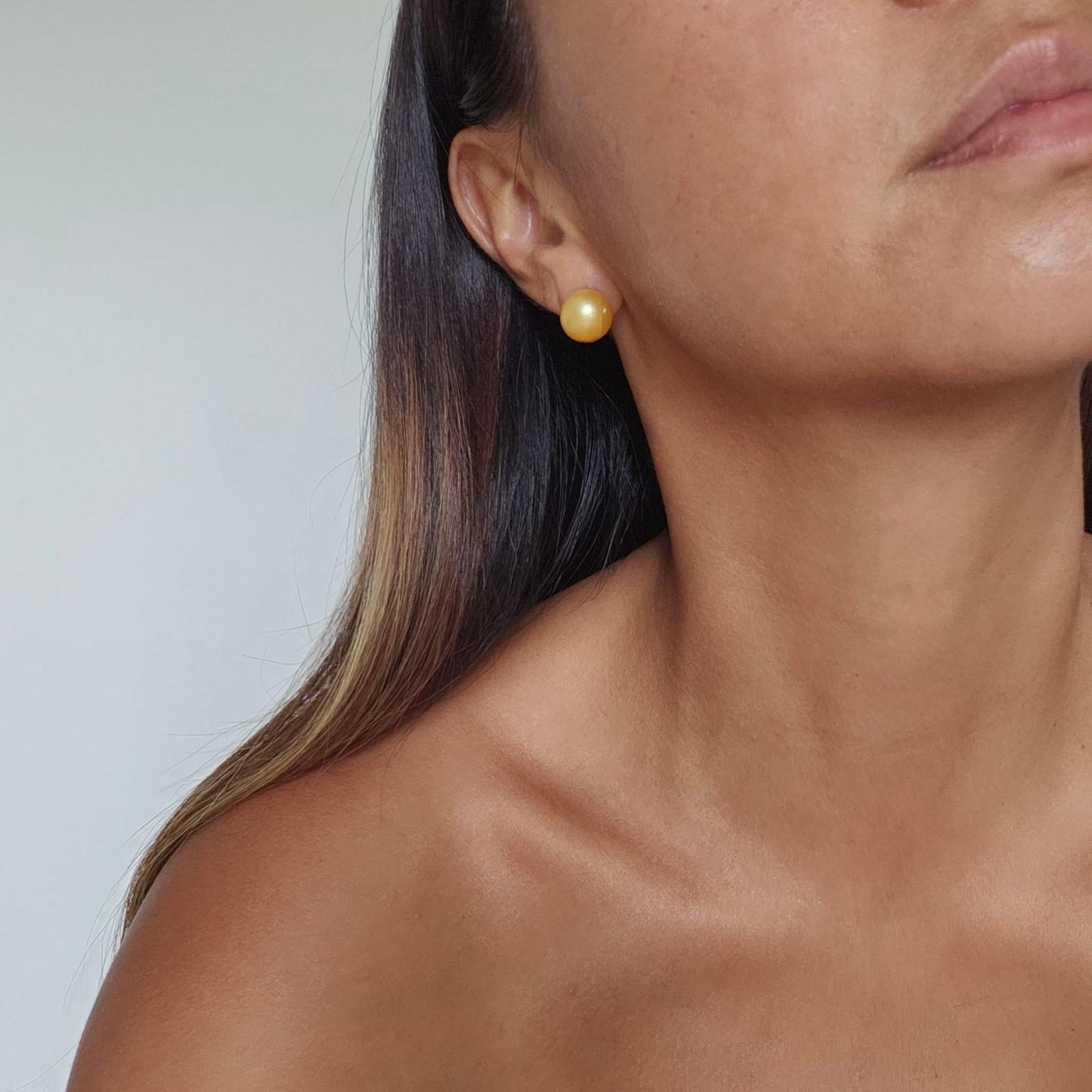 Side view of girl wearing large Golden yellow honey colored South Sea Pearl stud earrings set in 14k gold vermeil