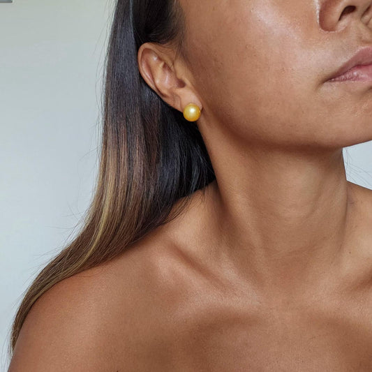 Profile of girl wearing large Golden yellow honey colored South Sea Pearl stud earrings set in 14k gold vermeil