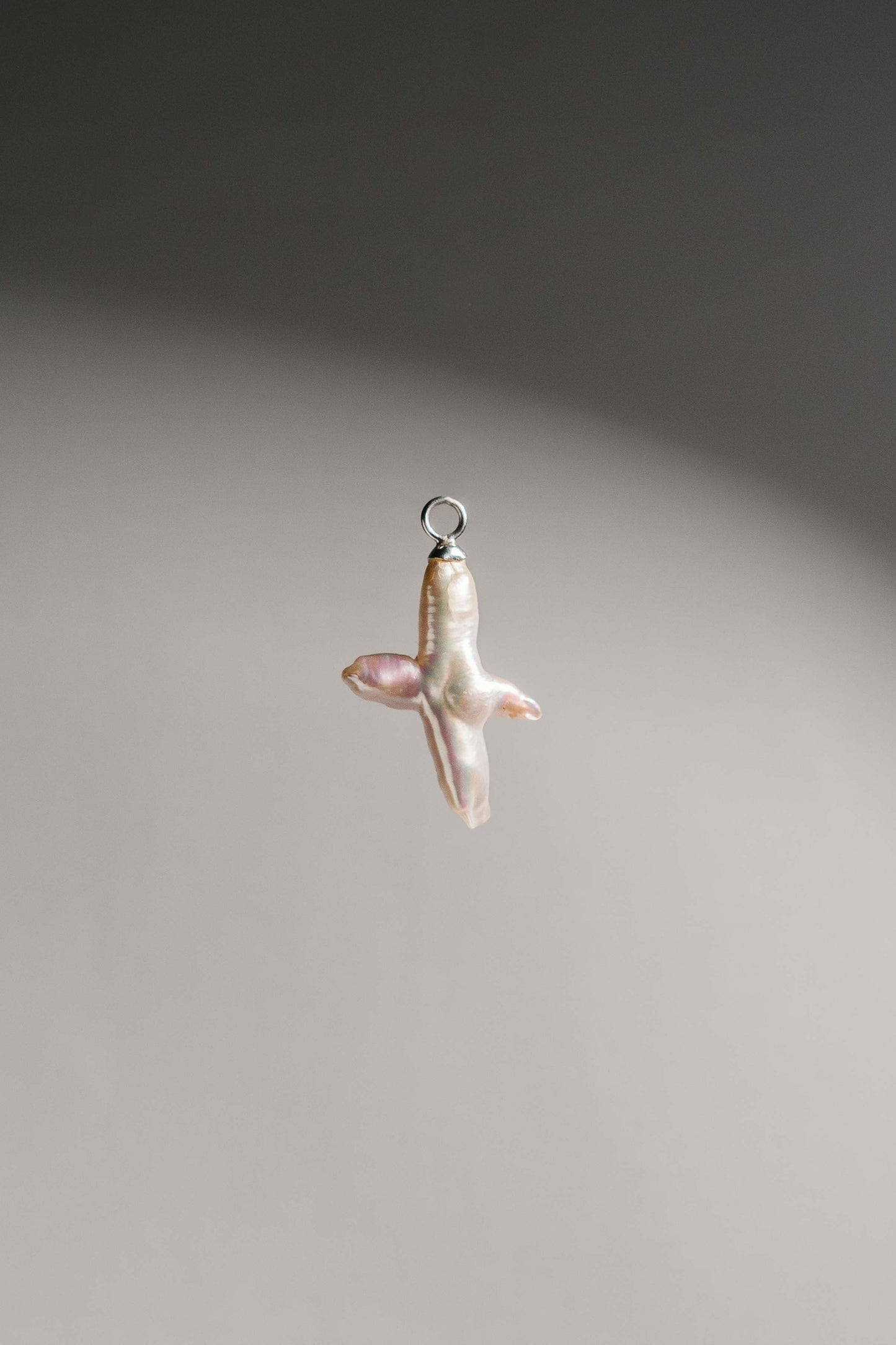 Product Shot of Cross-shaped Freshwater Biwa Pearl set in 925 Sterling Silver. Pair them with our Chunky Hoop Earrings or wear it as a necklace pendant. 