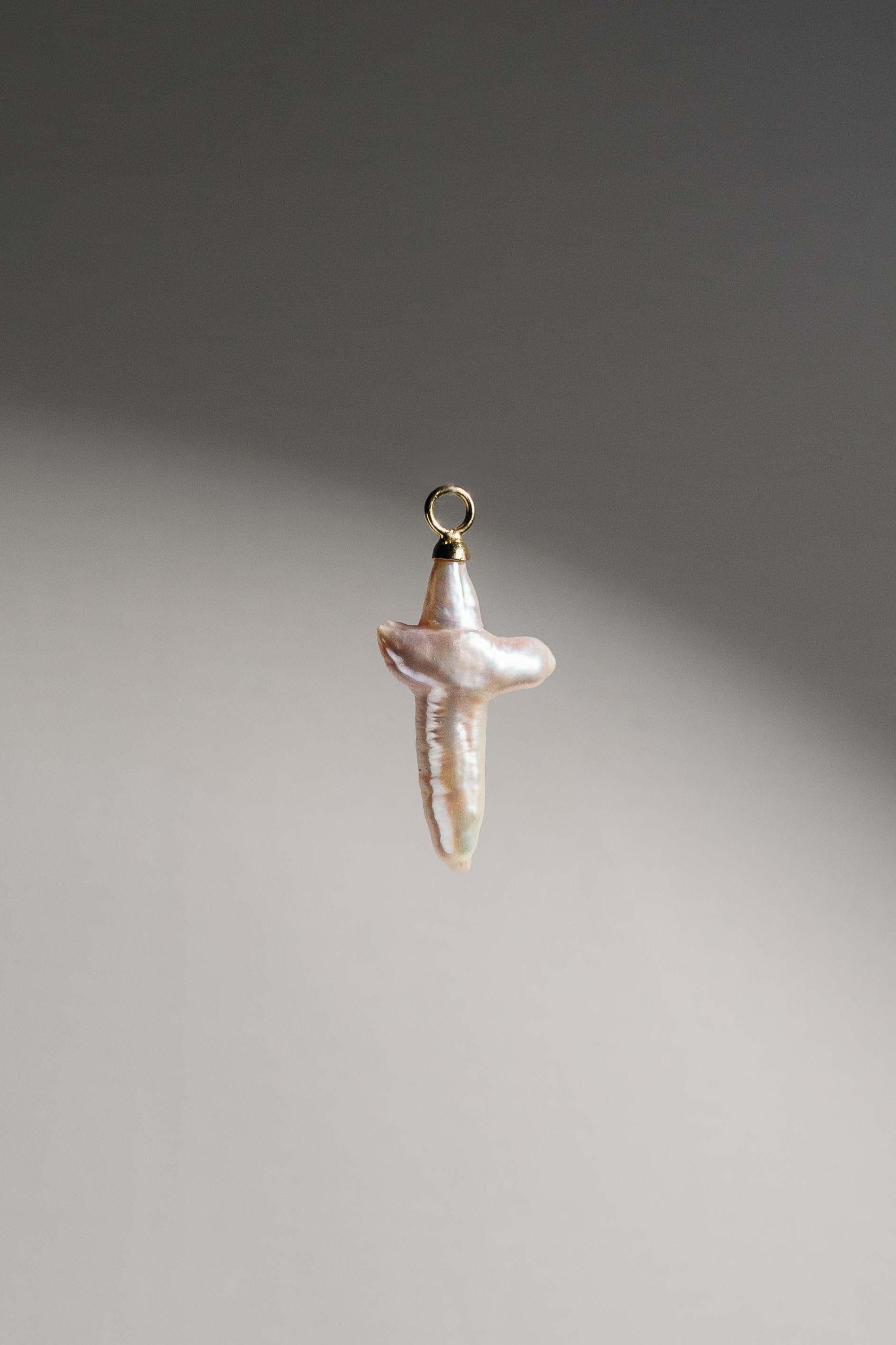 Product Shot of Cross-shaped Freshwater Biwa Pearl set in 14k Gold Vermeil. Pair them with our Chunky Hoop Earrings or wear it as a necklace pendant. 